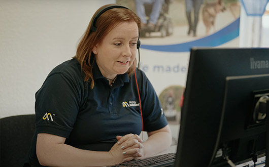 Employee wearing headset on computer