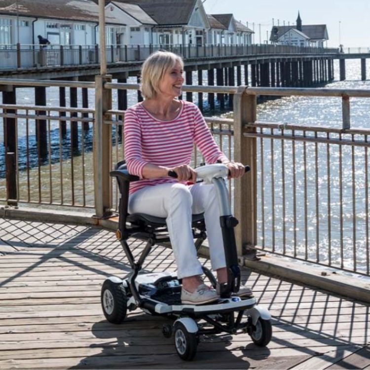Woman using TGA Minimo Plus scooter on a dock