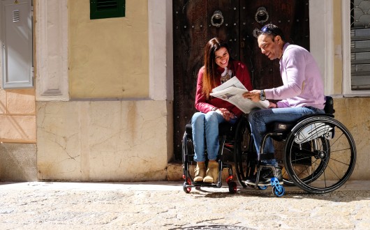 Couple on street in wheelchairs