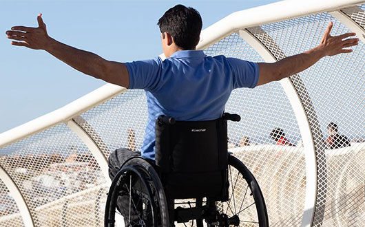 man in wheelchair with arms open