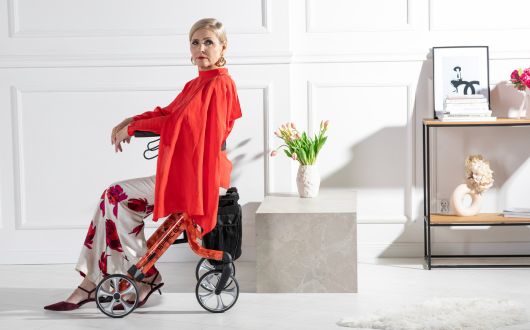 Woman using Space LX rollator with red peony design