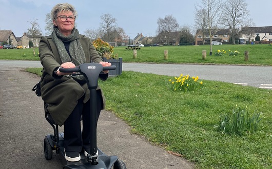 Woman using Go Go MG2 mobility scooter on pathway