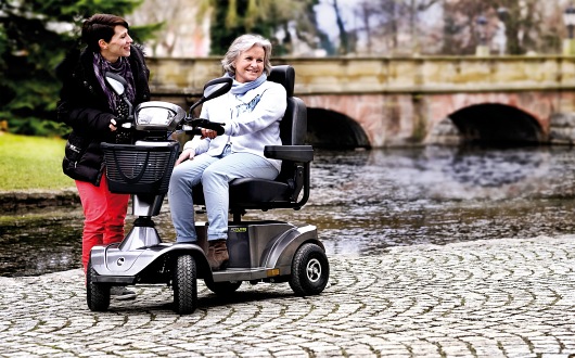Woman using S425 mobility scooter on cobble path