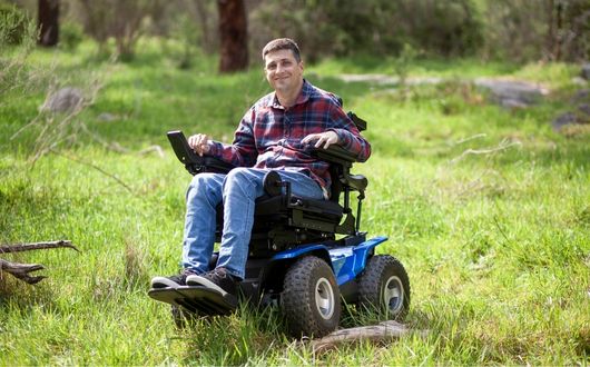 Man using XT4 powerchair outdoors on grass