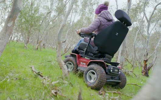 Woman going up grass hill on XT4 powerchair