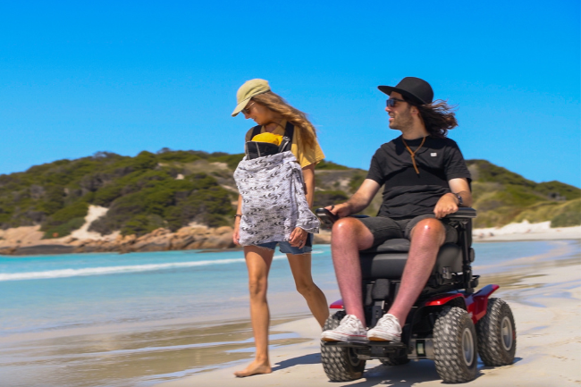 XT4 going on sand on the beach. Man in the XT4 while women with baby walks beside him