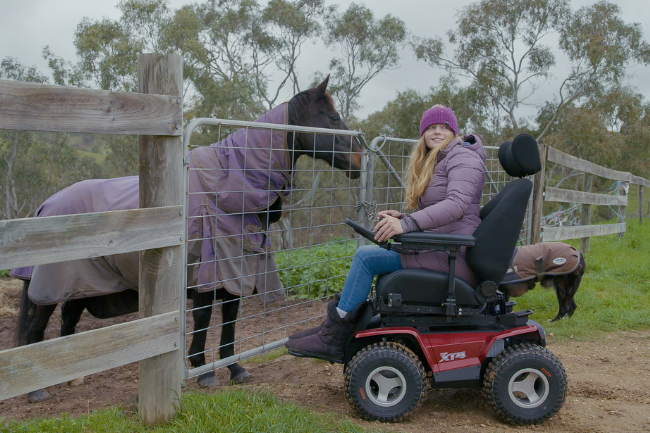Women in XT4 with a horse in the image behind a fence