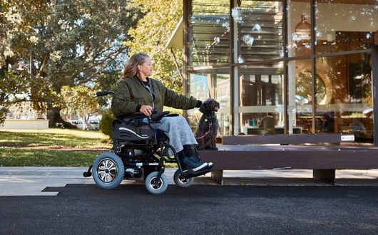 Woman walking dog whilst using powerchair
