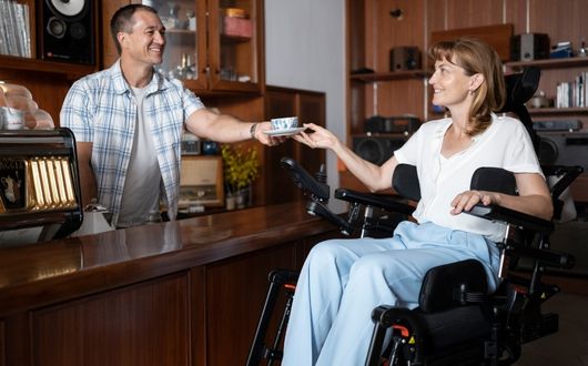 Woman using Morgan M powerchair at counter elevated