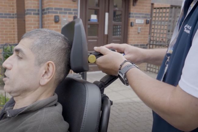 Powerchair headrest being adjusted by Mobility Solutions staff