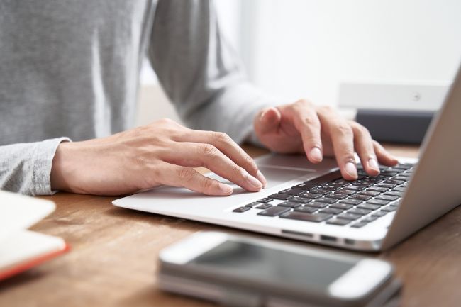 Close up of hands typing on computer