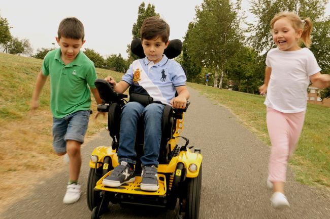Child playing with friends whilst using Kameleon powerchair