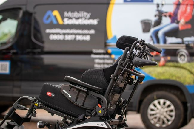 Close up of powerchair in front of Mobility Solutions van