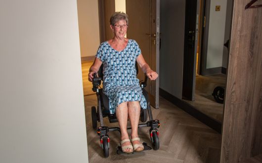 Woman going through doorway in powerchair.