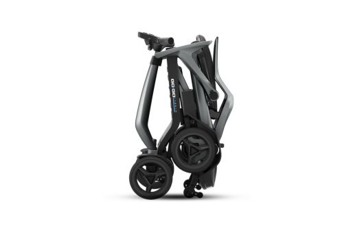 A compact, modern Carbon Ultra Lite mobility scooter folded for storage, shown from the side against a plain white background. The scooter features a sleek, grey design with black wheels.