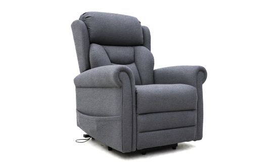 A grey upholstered Dallux Nevis recliner chair with padded armrests and backrest, slightly angled to the left. A power lead is visible at the base, suggesting the chair has electric reclining features.