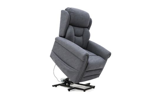 A grey upholstered Dallux Nevis recliner chair with an electric lift mechanism, partially raised to assist the user in standing up. The chair has padded armrests and a lead connected to the base.
